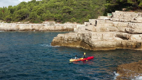 vista de viajeros en kayak cerca de acantilados y cuevas de pula, istria, croacia - disparo de drones