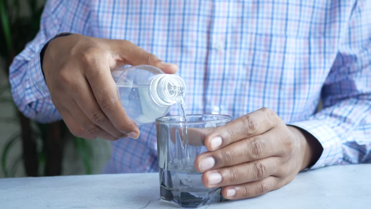 병에서 물을 유리잔에 부어 넣는 것