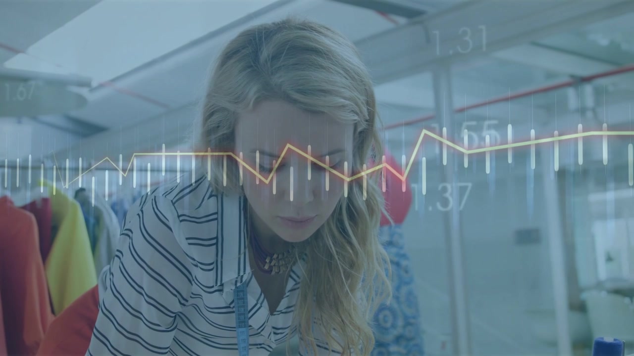 Fashion designer leaning over table, preparing garment while bars and line graph overlaying frame