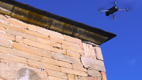 drone flying next to the roof of a romanesque church