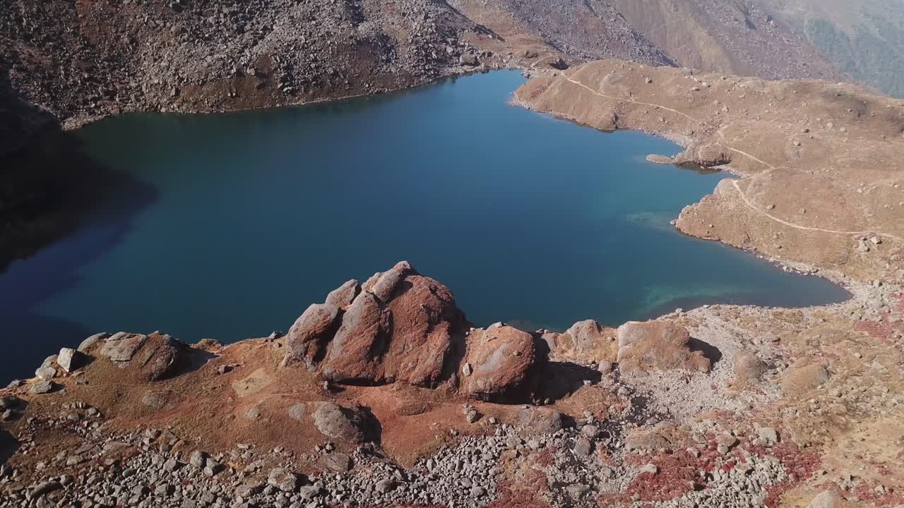 A stunning aerial view of Gosaikunda Lake in Solukhumbu shows its sacred blue water set amid rugged Himalayan terrain. The high-altitude scenery highlights the lake’s natural beauty