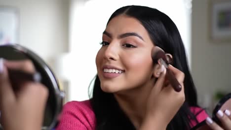 a young woman applying makeup: captivating transformation through skillful brush techniques in a bright indoor setting