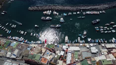 Marina-Corricella-port-on-Procida-Islands,-Waterfront-colourful-housing-rooftops,-Ferries-and-Hydrofoils-at-Bay,-Italy