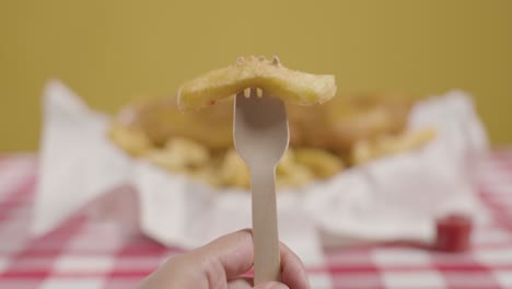 person eating traditional british takeaway meal of fish and chips 1