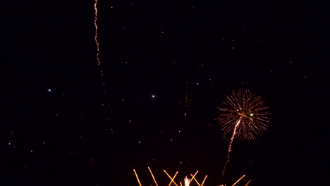 múltiples exhibiciones de fuegos artificiales de colores explotando en un cielo negro oscuro durante la víspera de año nuevo
