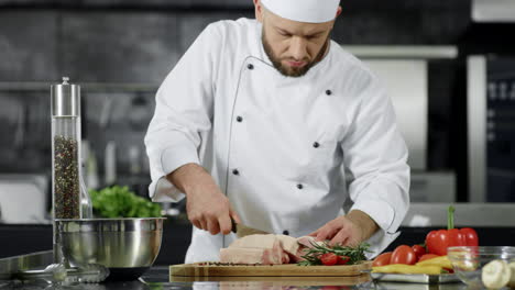 Chef-cutting-pork-fillet-at-kitchen.-Man-chef-preparing-meat-in-slow-motion