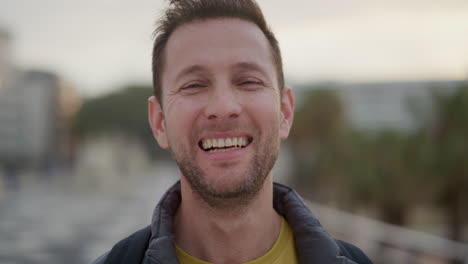 close up portrait happy young man tourist laughing enjoying successful vacation travel indepenent caucasian male in city waterfront