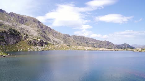 Impresionante-Paisaje-De-Un-Lago-Ondulante-Rodeado-De-Montañas-Rocosas.