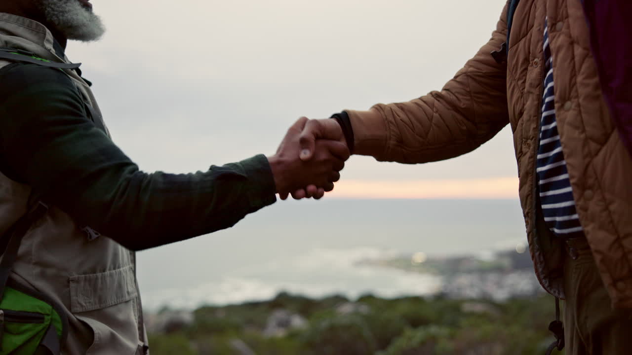 Two people shaking hands outdoors