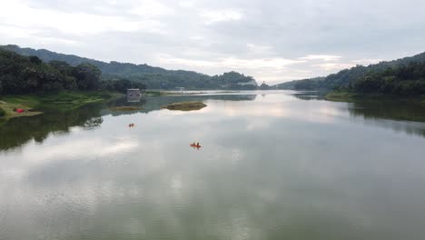 asian people canoeing on a reservoir with a beautiful view