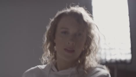 head and shoulders studio shot of young woman having fun dancing against grey background