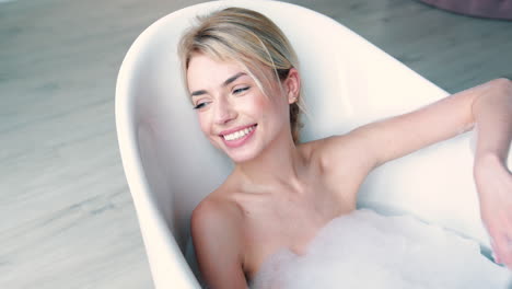 woman lying in bathtub full of foam