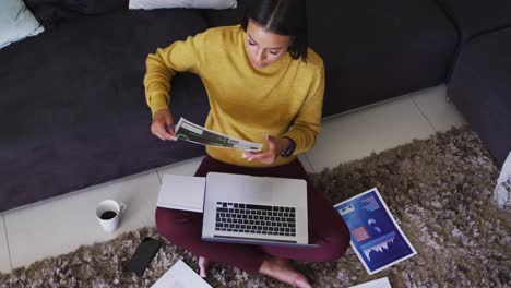 Mujer-De-Raza-Mixta-Sentada-En-El-Suelo-Usando-Una-Computadora-Portátil-Revisando-El-Papeleo