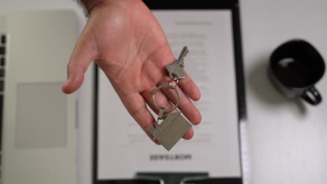 hispanic male hand handing over house keys