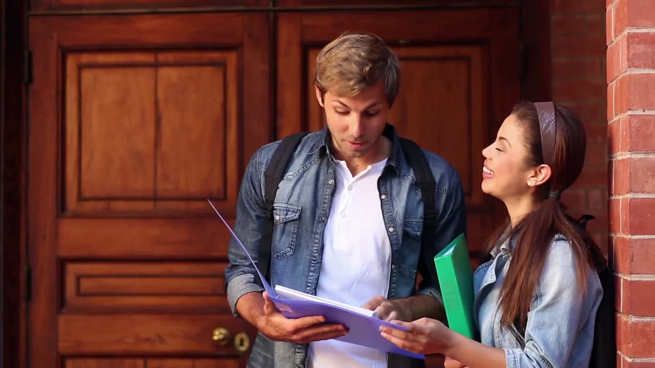 estudiantes felices leyendo de la carpeta juntos