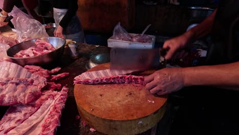 butcher slicing and packaging pork ribs