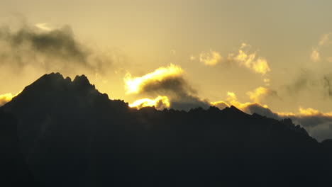 sun glowing over the ridge of a mountain french alps sunrise yellow sky