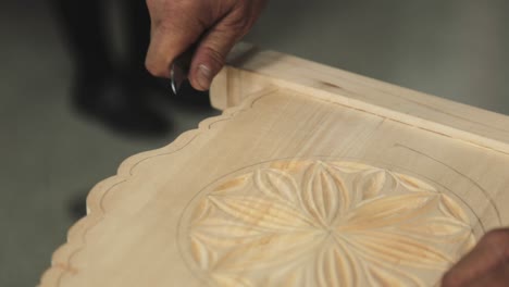 un hombre grabando su cuna de madera