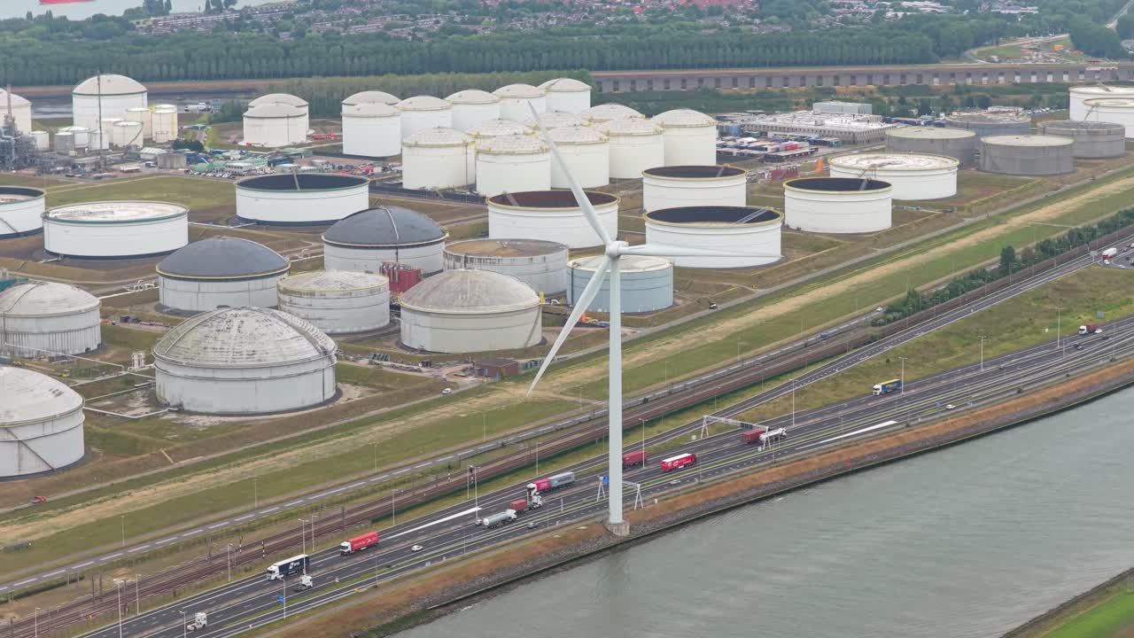 空撮：オランダの石油化学施設にある貯蔵タンクと風力タービン
