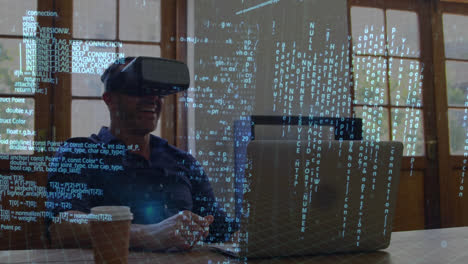 man wearing virtual goggles while using a laptop