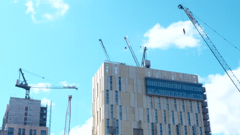 low angle shot of cranes and construction on top of building, woking surrey