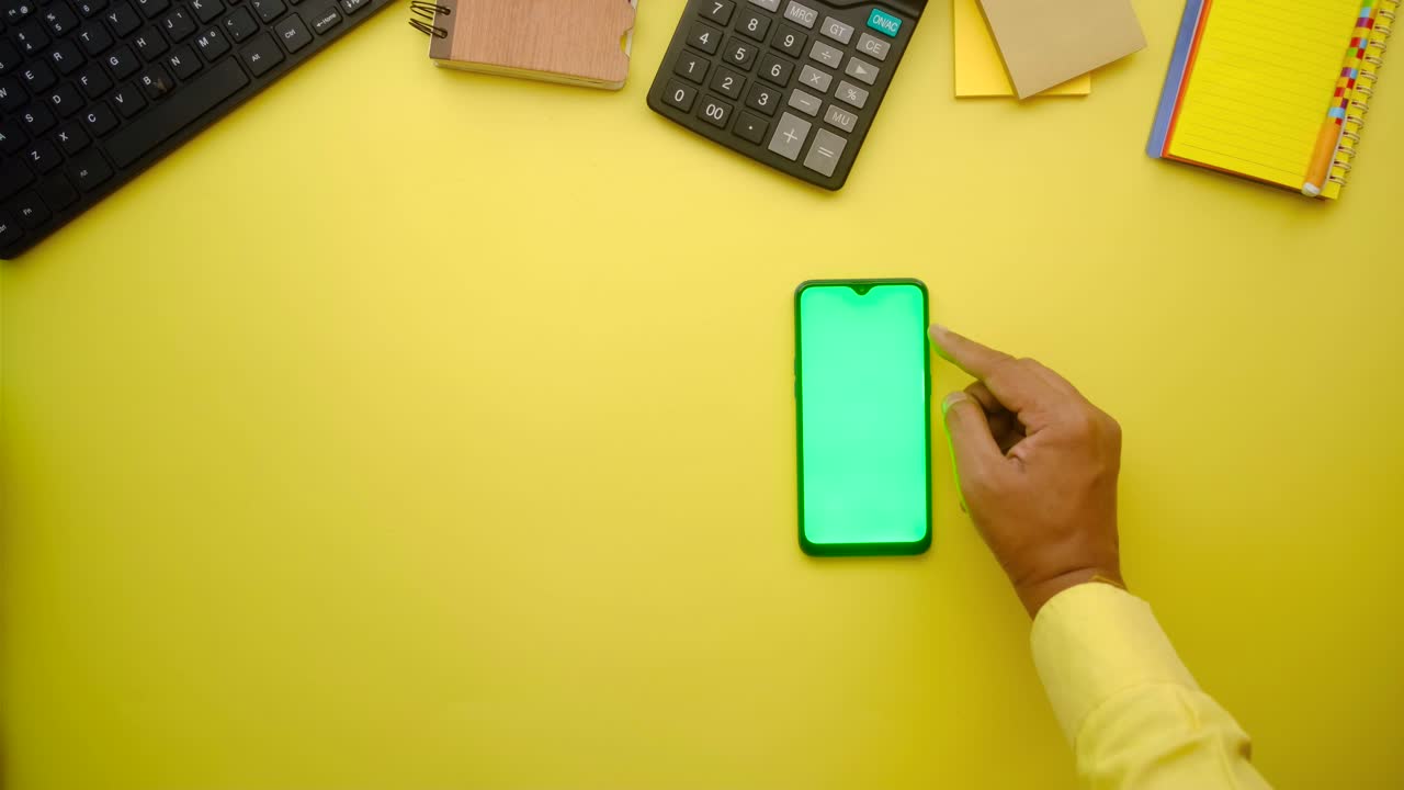 Person working at a desk with a mobile phone