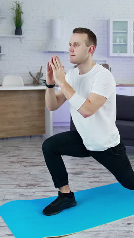 healthy athletic man training in home.fit man in t-shirt doing exervises. vertical video