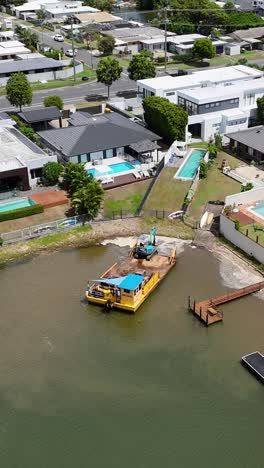 imágenes de drones capturan una barcaza navegando por un canal en un área residencial, mostrando vías fluviales urbanas y la arquitectura circundante