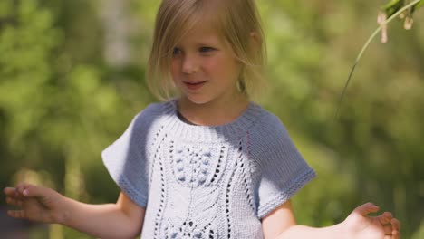 a young fair-haired girl poses trying to make a serious face