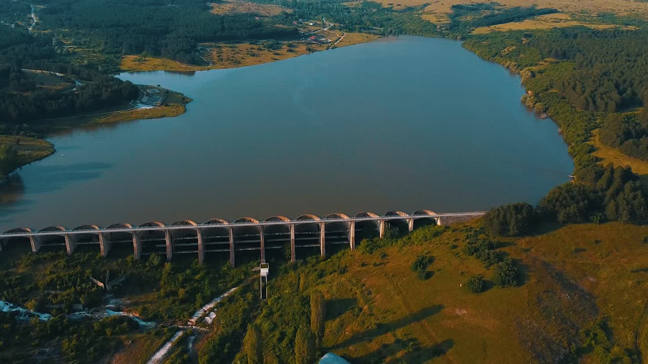 Drone shot of a lake blocked by a long dam