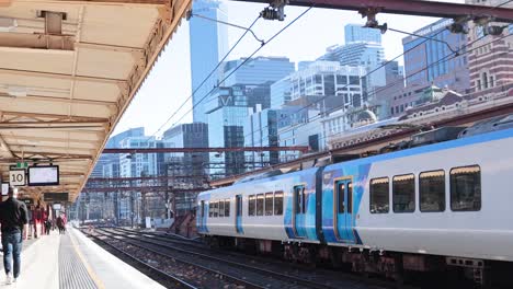 train arrives at a busy urban platform