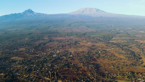 Sonnenaufgang-–-Kenia-Landschaft-Mit-Einem-Dorf,-Kilimandscharo-Und-Amboseli-Nationalpark-–-Verfolgung,-Drohnen-Luftaufnahme