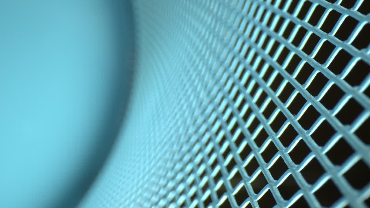 Pulling away from a metal lattice grid where the bottom portion is completely DEFOCUSED, pulling attention to the macro view of the metal on the right side