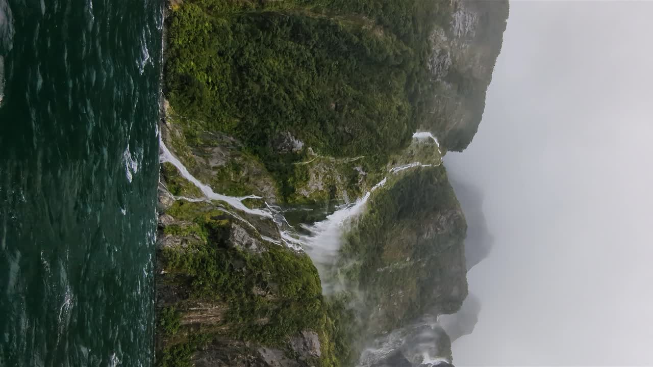 Verticale delle cascate della Nuova Zelanda a Milford Sound durante una stagione piovosa con tempeste di grandine e vento