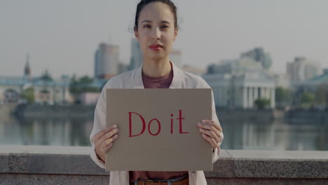 woman holding a sign saying 'do it'