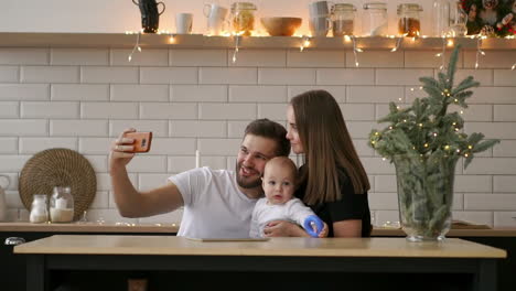 family, parenthood, technology and people concept - happy mother, father and little boy having dinner and taking selfie by smartphone at restaurant