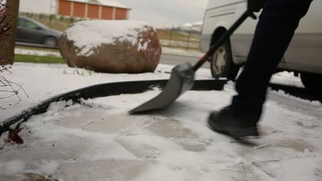 man shovels fluffy snow off a walkway