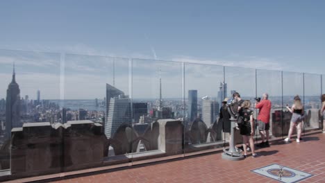 tourists taking pictures of manhattan from observation deck