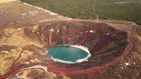 różne ruchy dronów pokazują krater kerid na islandii, w częściowo zamarzniętym krajobrazie