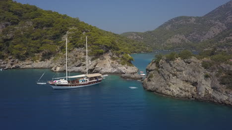 Tourist-back-flips-off-high-rock-cliff-in-bay-by-live-aboard-tour-boat