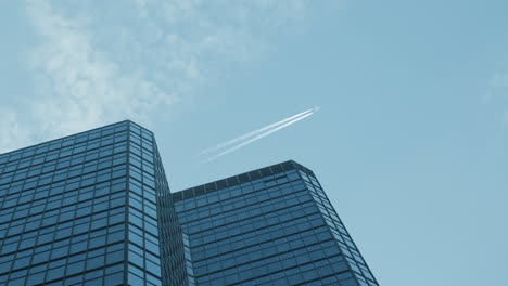 looking-up-view-of-city-skyline-buildings-with-aircraft