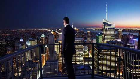 businessman overlooking new york city at night