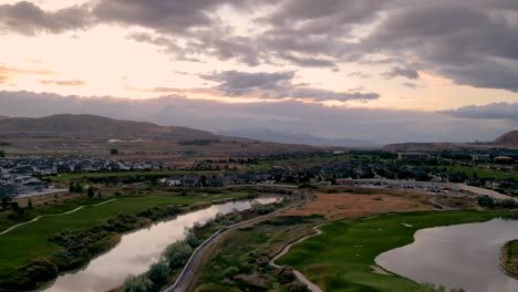 stunning sunset aerial hyperlapse of an idyllic community along a river and golf course