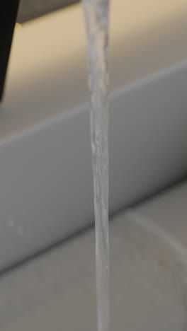 agua que fluye de un grifo a un fregadero