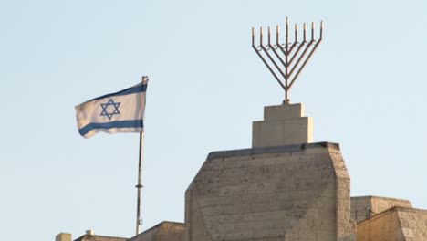 bandera nacional israelí ondeando en el viento junto a un gran hanukkah