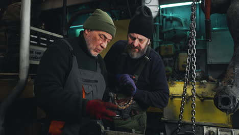 two senior mechanics working on a ship engine