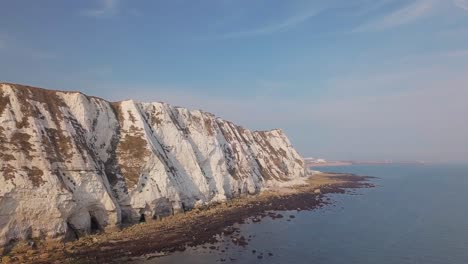 el dron vuela bajo hacia los acantilados blancos de dover con la cámara girando a la derecha