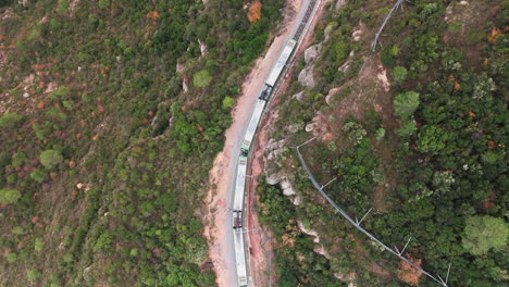 drone top down shot follow train on windy mountain track