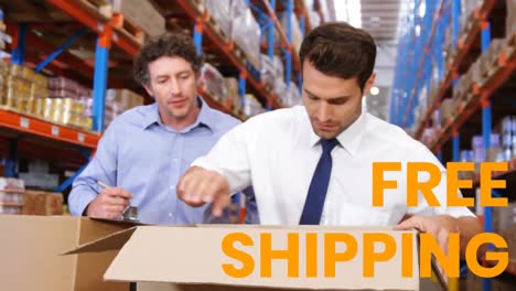 Animation-of-the-words-Free-Shipping-over-men-working-in-a-warehouse-checking-boxes