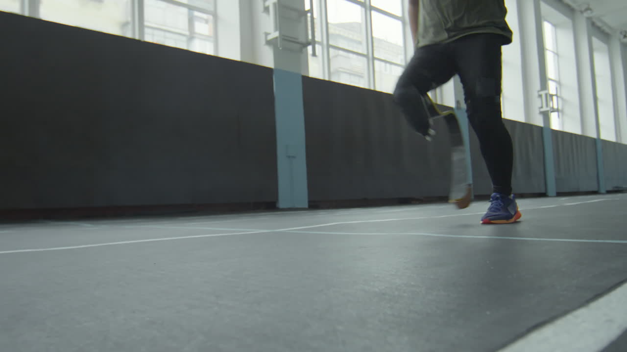Sprinter with Prosthetic Limb Running in Stadium